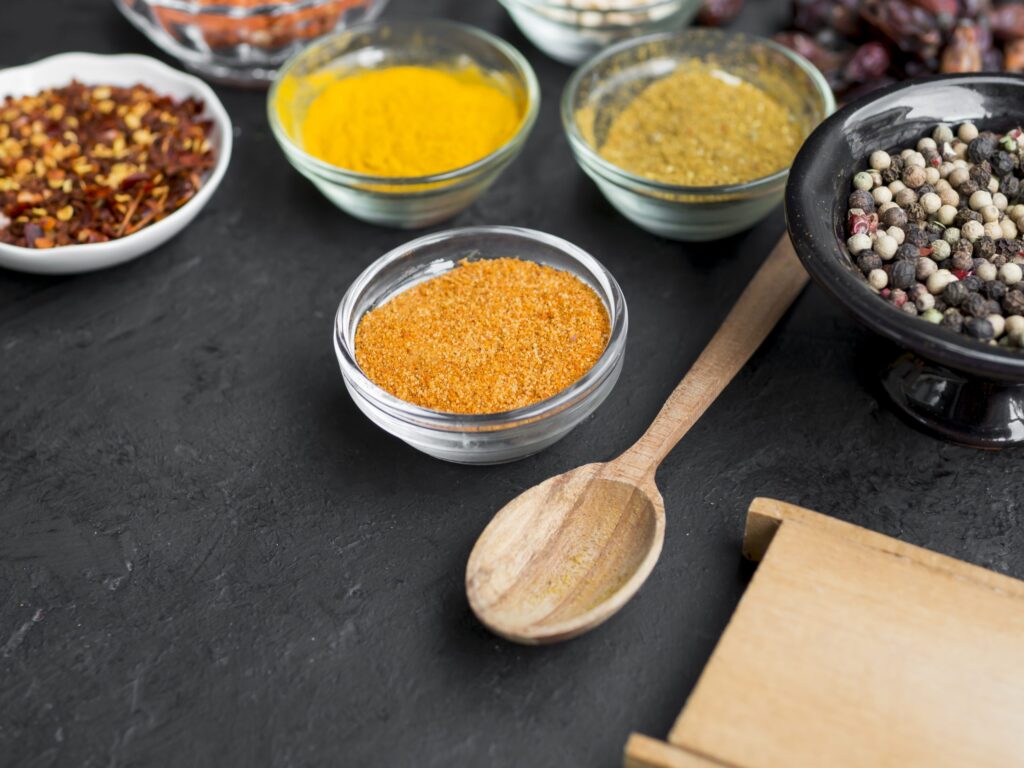 Especiarias portuguesas: o toque especial da culinária 1 grupo de tacas cheias de especiarias em fundo preto scaled 1