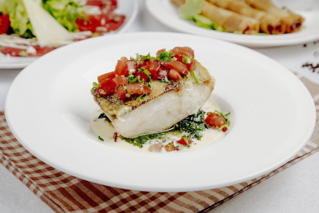 vista lateral de robalo assado com tomates scaled 1